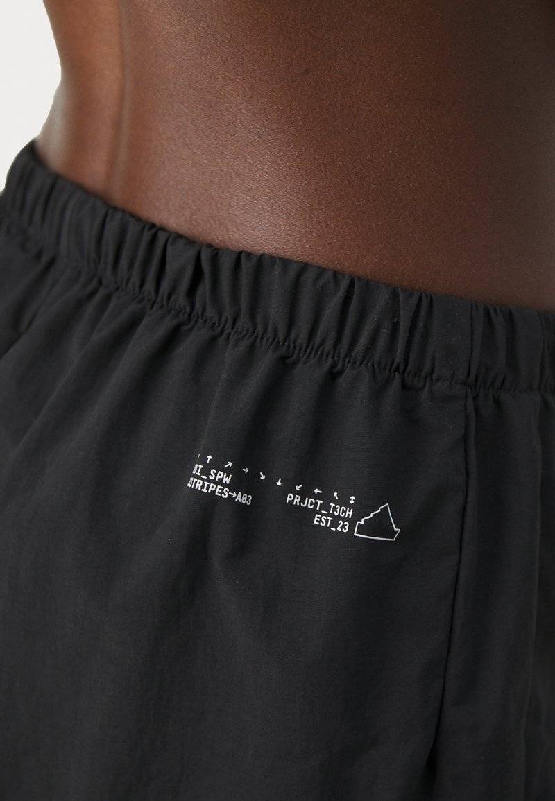 adidas Sportswear adidas Sportswear CITY ESCAPE WOVEN PARACHUTE - Trousers - black Top Angebot